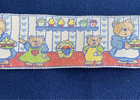 Decorative ribbon with teddy bear design on a blue fabric background